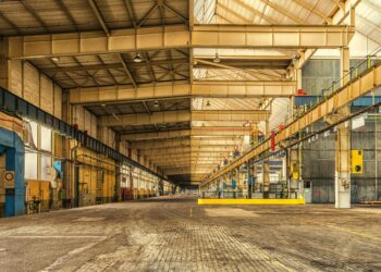 Expansive interior of an industrial warehouse showing steel beams, high ceilings, and ample space.